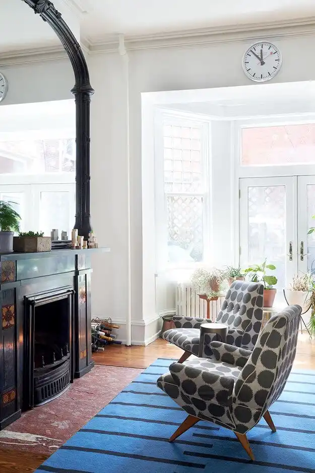 White painted room with a black fireplace and mirror