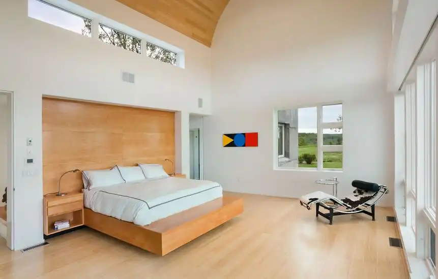 Wooden platform floating bed on a high ceiling bedroom