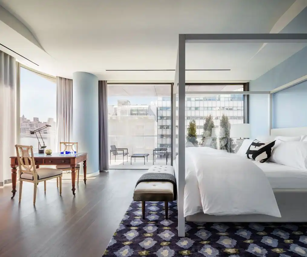 The pale blue walls in this bedroom in a Zaha Hadid-designed building fit the view and setting.