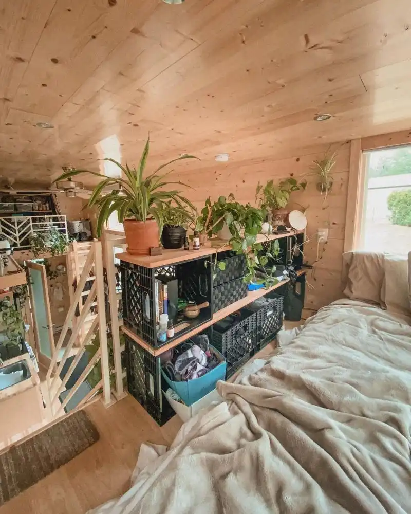 The sleeping area has a small closet made out of repurposed crates and wood planks