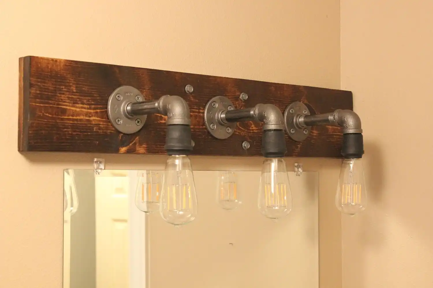 Diy industrial bathroom light featuring edison bulbs