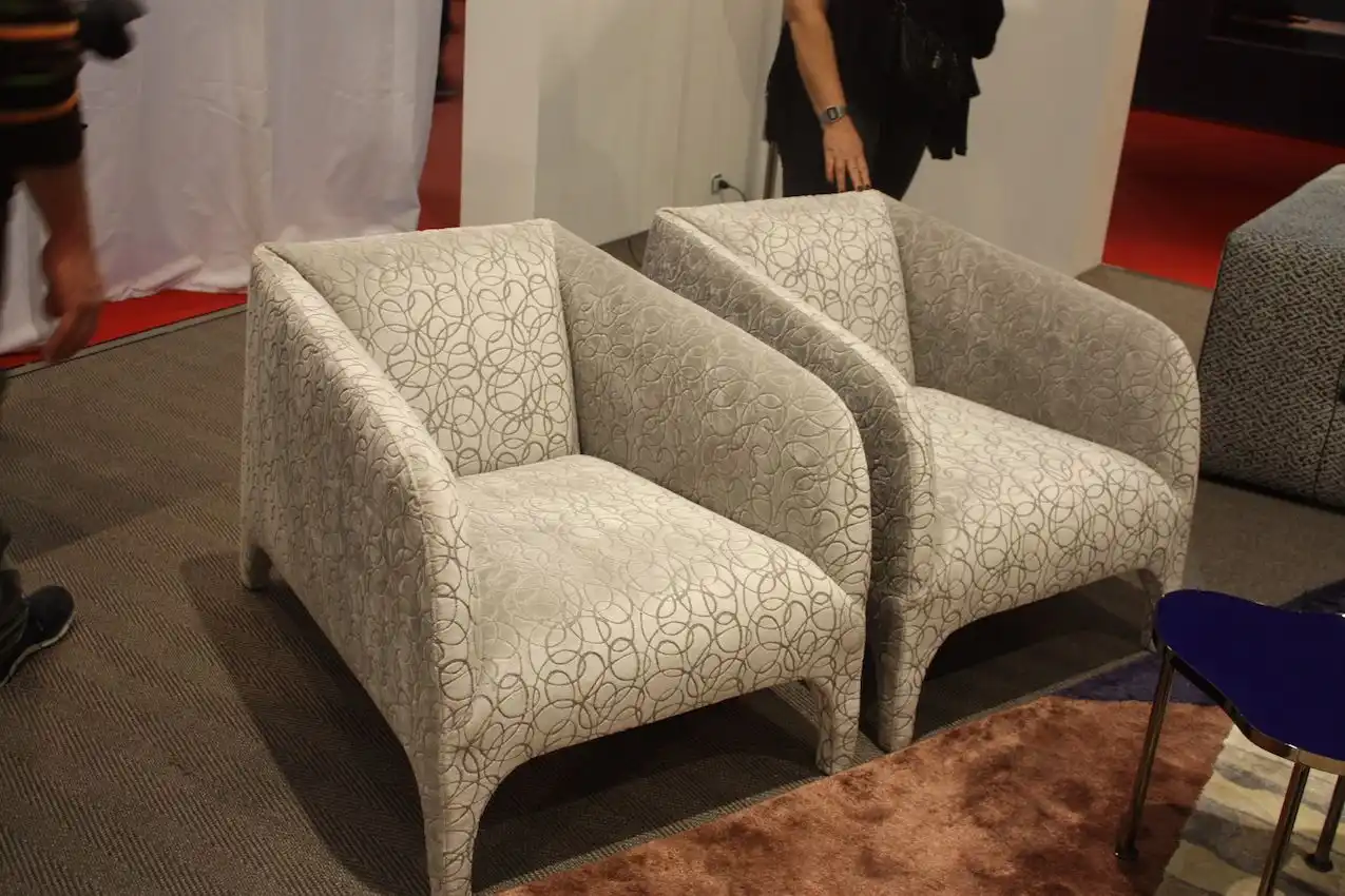 A more elegant take features upholstered legs and smoothly angled armrests.