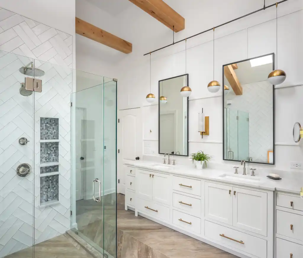 white bathroom with chevron subway tiles and brass hardware