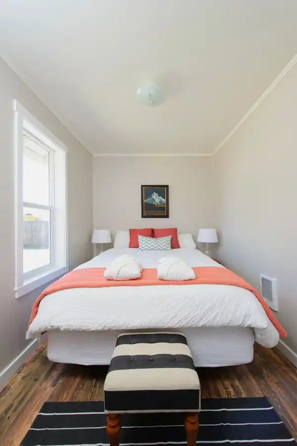 Tiny narrow bedroom coral accents