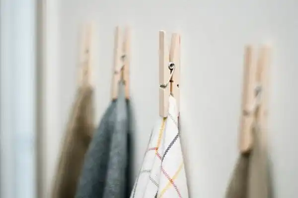Use clothes pins to hang kitchen towels