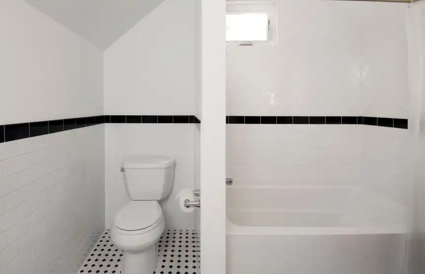 White bathroom floor toilet and wall divider between