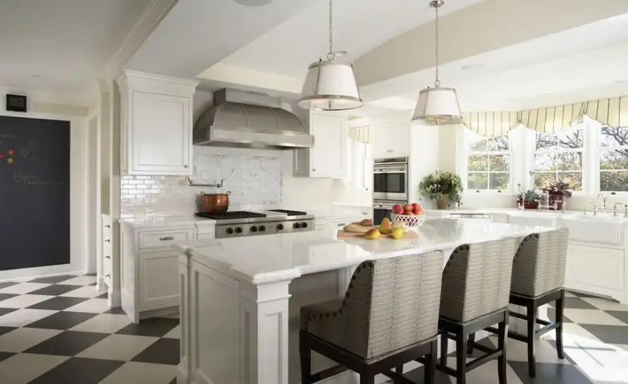 White kitchen with marble features and island counter chairs