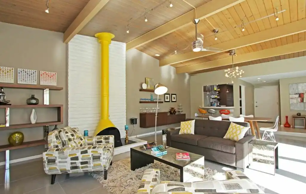 Yellow fireplace in large living room visible rafters 1024x649