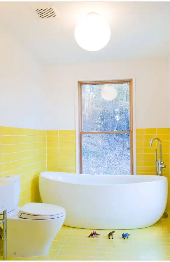 Yellow tile standing tub window and dinosaurs in bathroom
