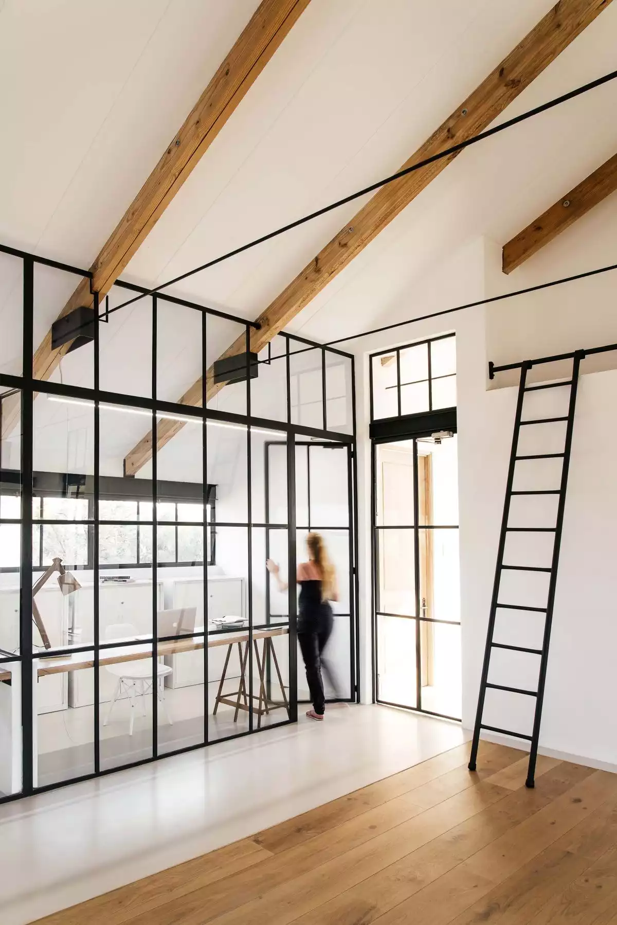 Glass walls and partitions matching the facade walls seamlessly connect various sections of the house