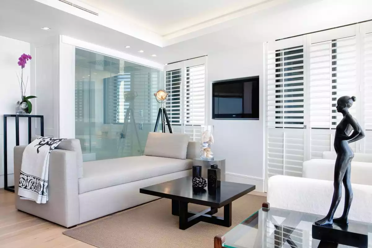 Dark accent pieces and black details highlight the decor and contrast with the white walls and ceilings