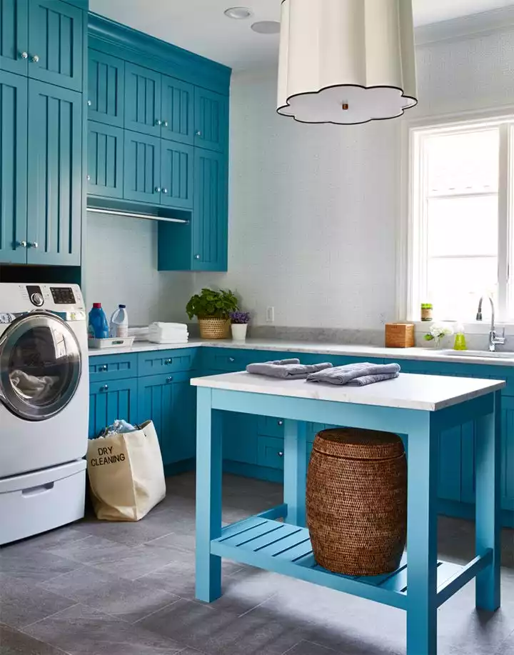 Deep blue shade laundry room decor with a small island