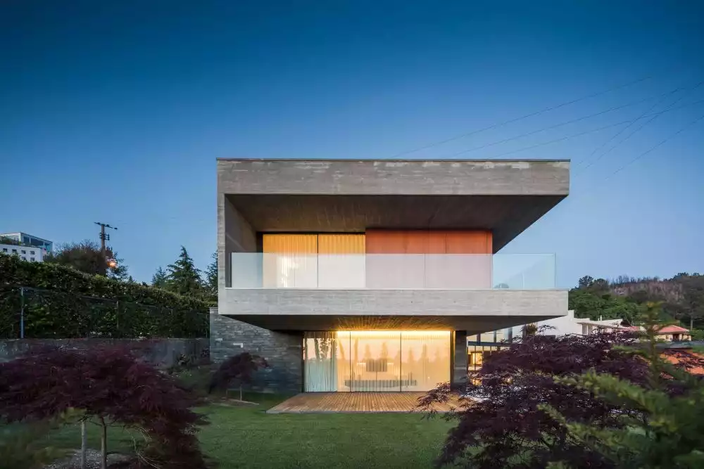 Floor-to-ceiling windows open up the house to its surroundings, allowing natural light to enter the rooms