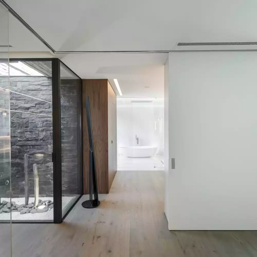 Beautiful wood flooring and white walls ensure a nice fluidity throughout the house, connecting all the different functions