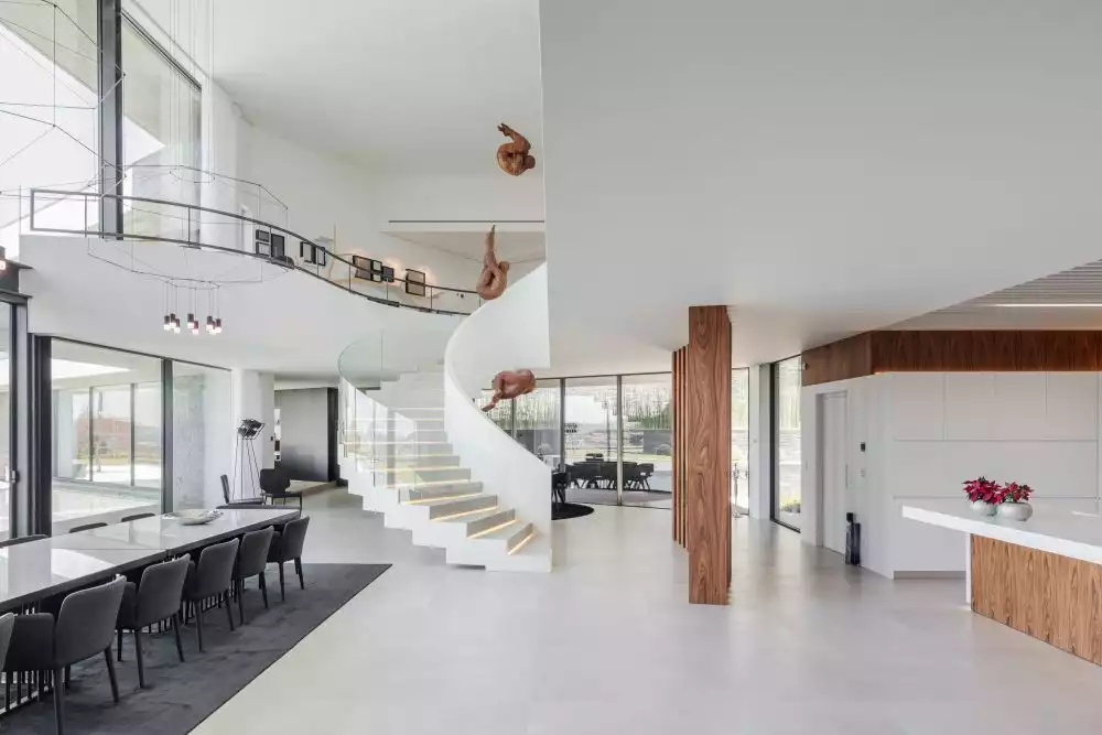 A graceful spiral staircase connects the ground floor to the upper level. It looks like a beautiful, giant sculpture