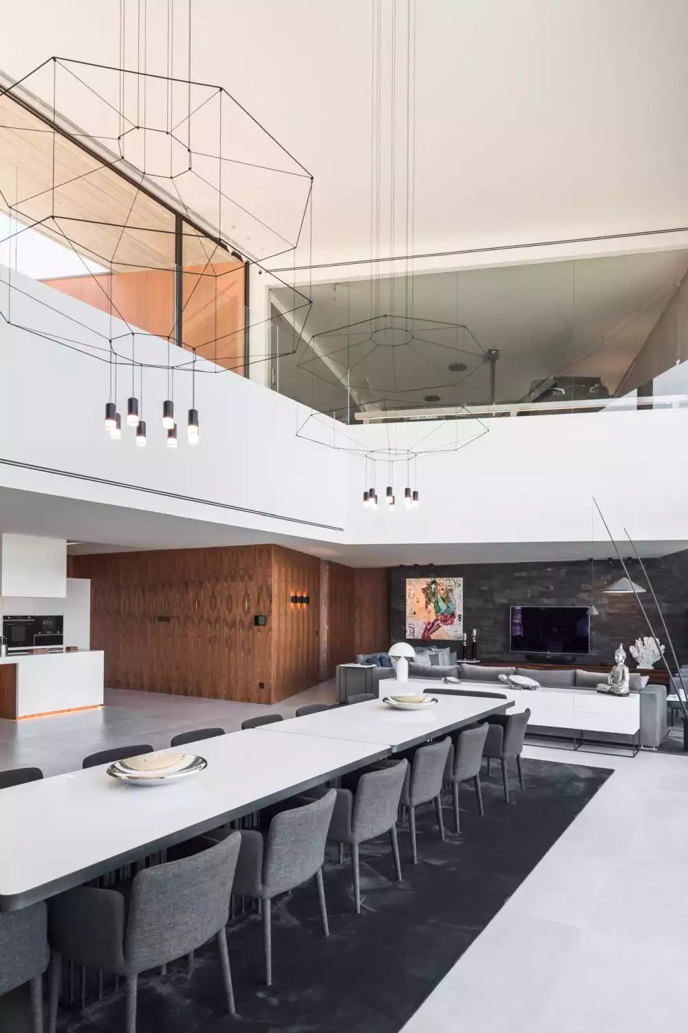 Two sleek and graphical-looking chandeliers hang above the large dining table