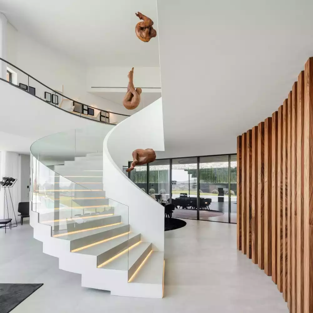 The spiral staircase has LED light strips on each step and a transparent glass outer railing