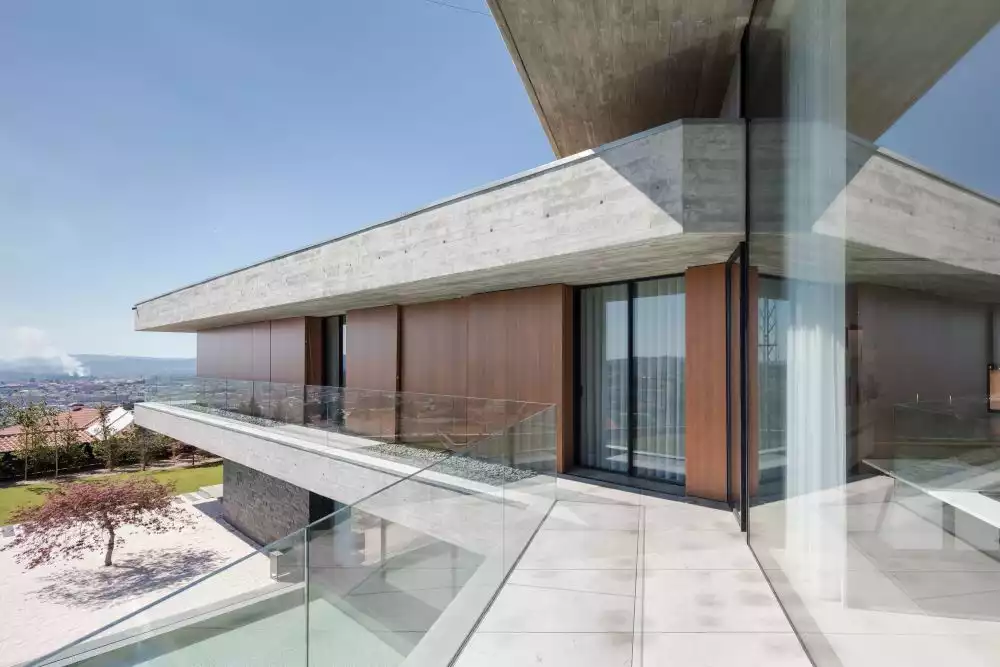 The private volumes are frame by long open balconies with glass railings