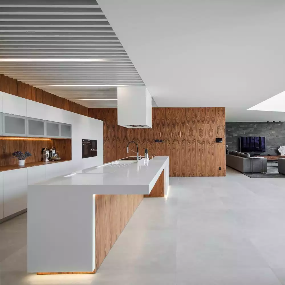 The kitchen is part of the open plan social area but is positioned outside of the double-height volume