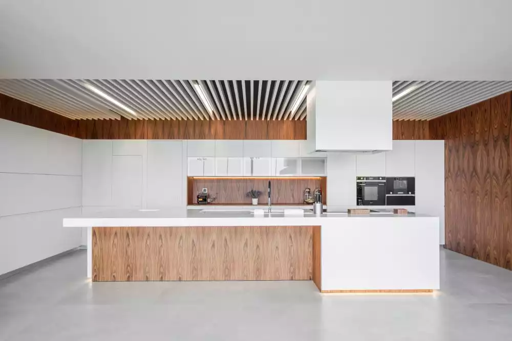 A large kitchen island capable of doubling as a bar or breakfast table showcases the perfect balance of colors used in this space