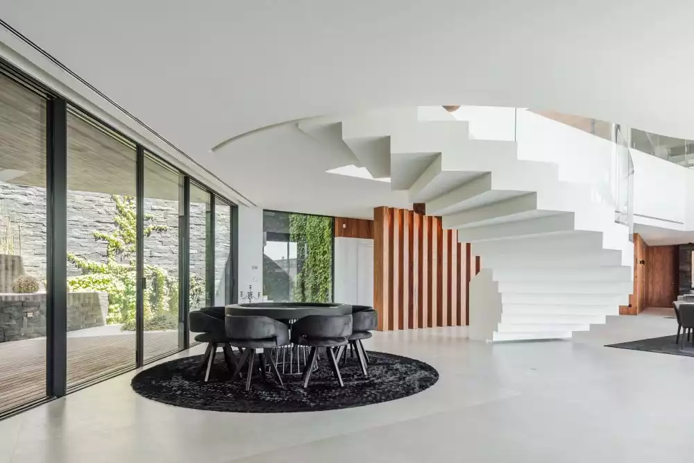 Under the staircase there's a smaller and more intimate dining space with a round table and a matching rug
