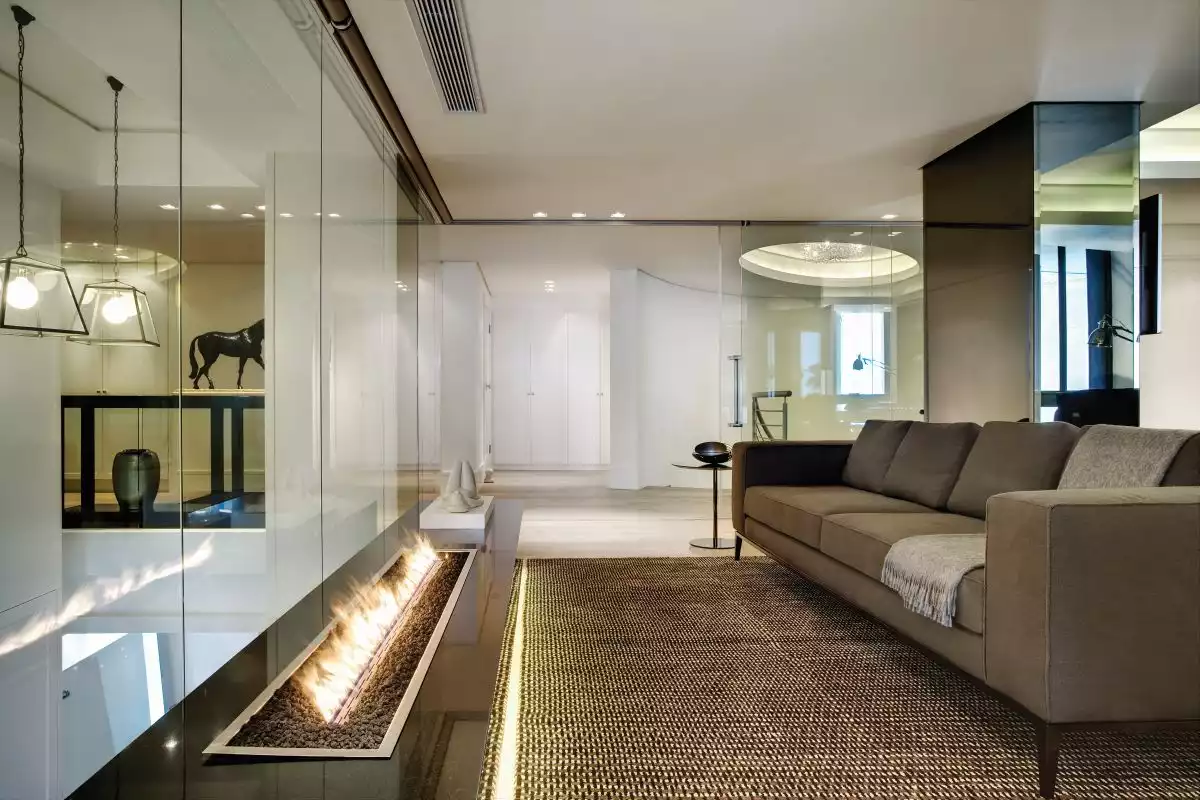 A secondary living area on the upper floor features an elegant sofa facing a contemporary fireplace