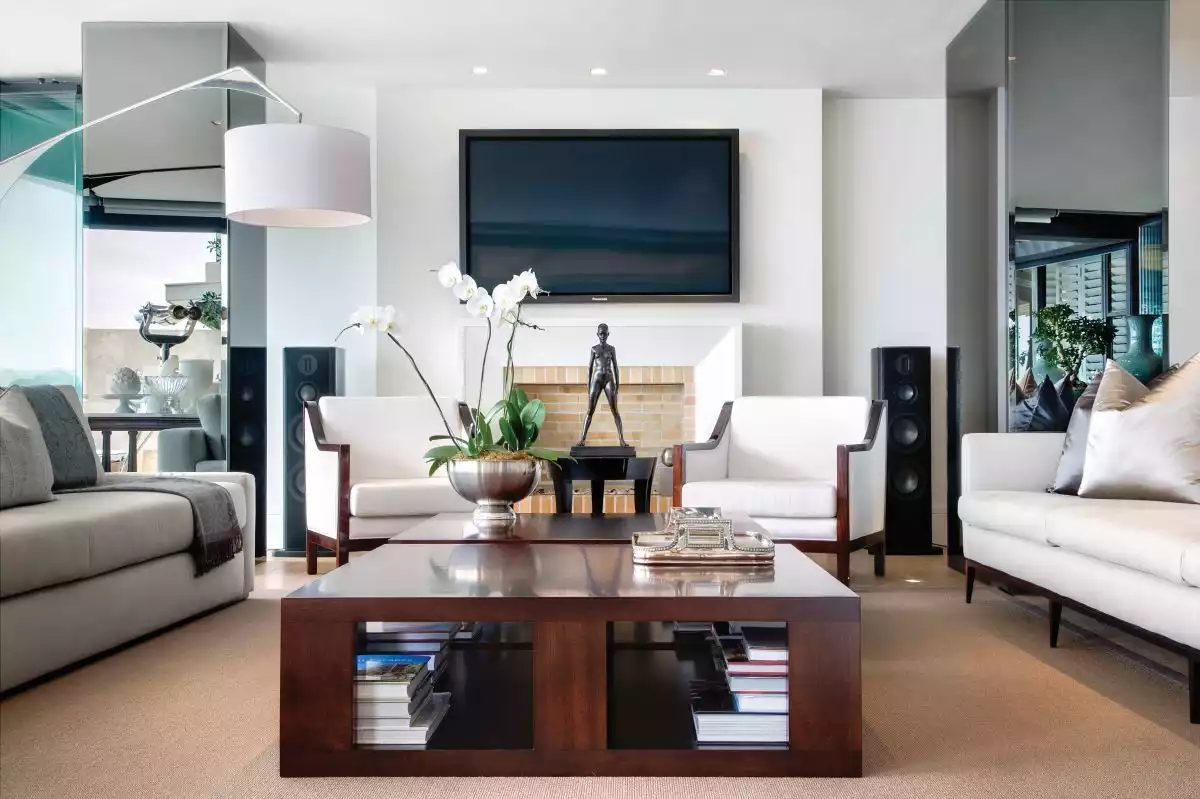 An oversized floor lamp complements the lounge area, extending over the sofa, towards the mahogany coffee table