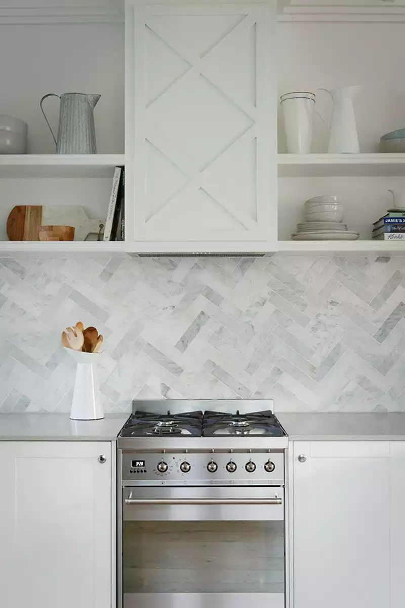 Marble backsplash with heringbone pattern