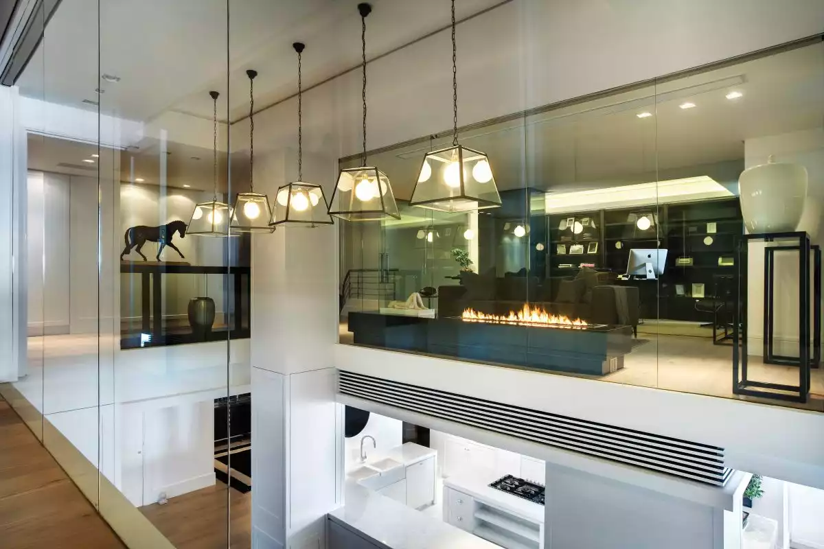Glass walls and full-height windows allow the light to travel throughout the spaces, ensuring a sense of openness and transparency