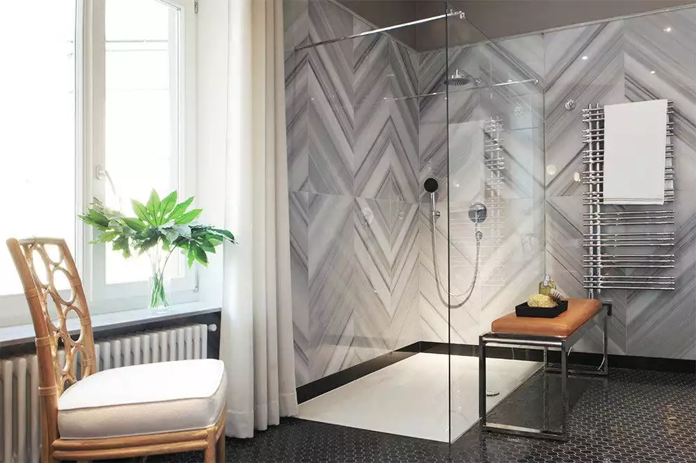 Walk in shower with marble chevron pattern