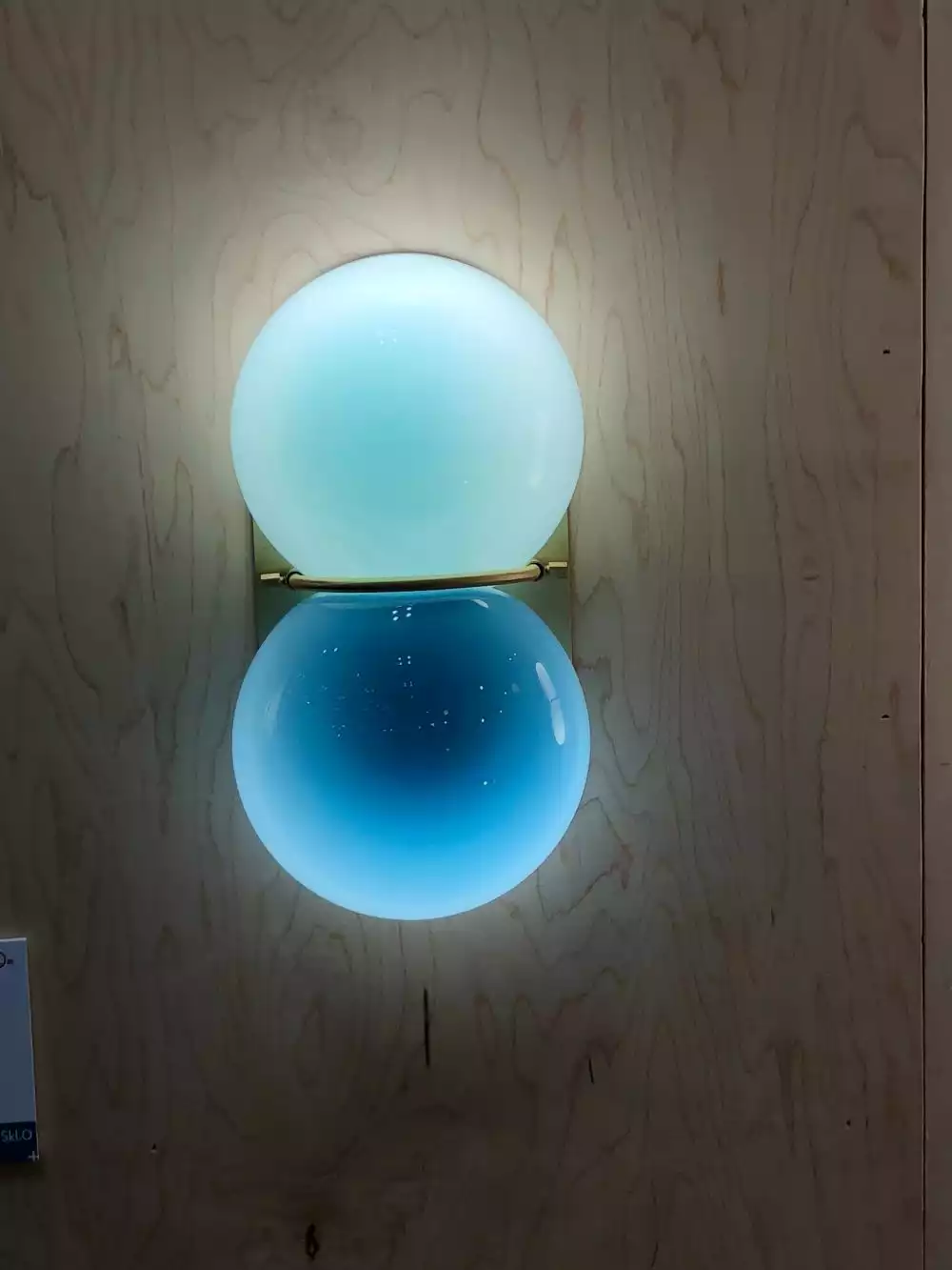 Wall sconce featuring glass balls in blue shade