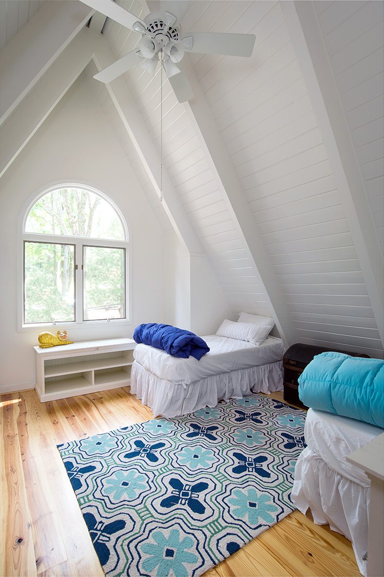 A frame cabin white attic bedroom