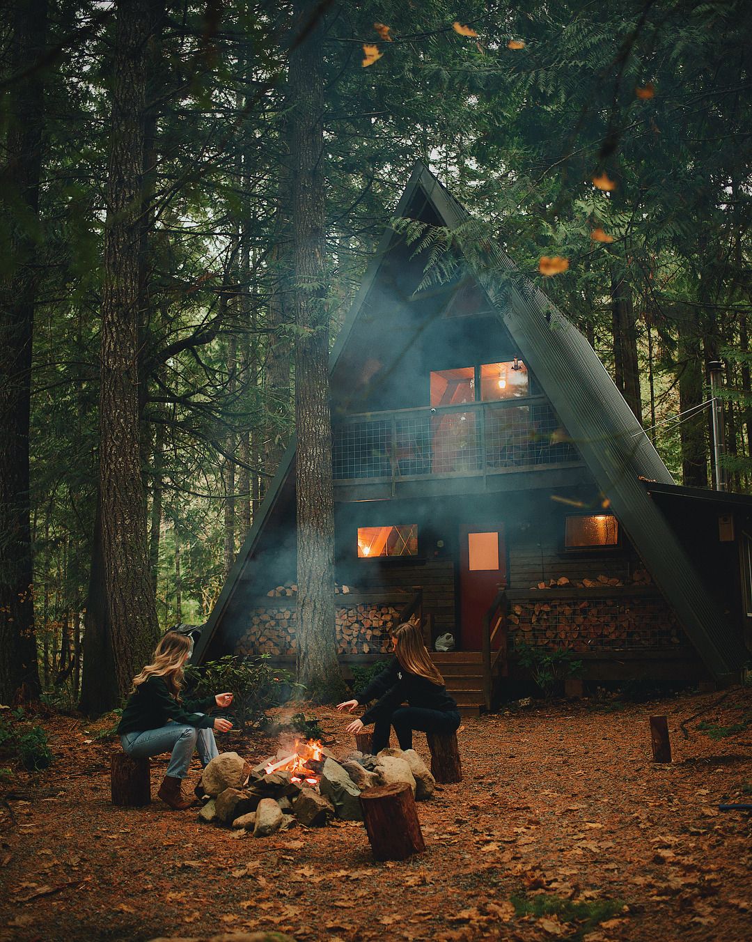 A frame cabin with wood storage on patio