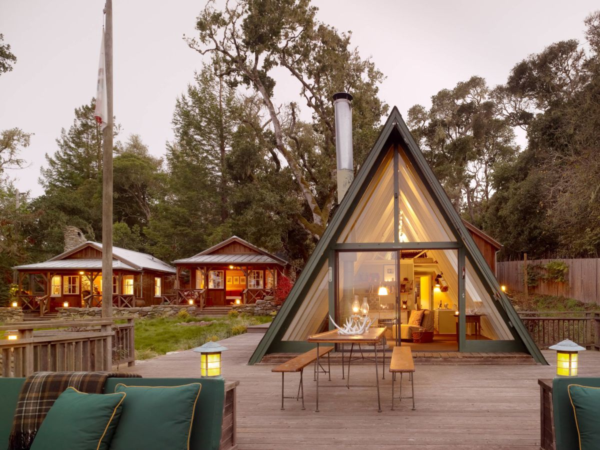 a frame cabin with large glass windows