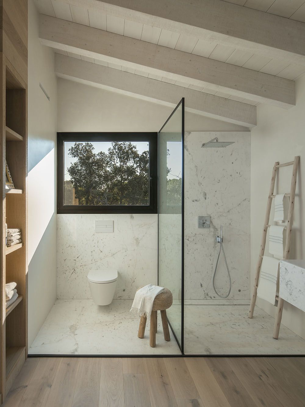 A glass wall between the shower and toilet maintains the open plan.