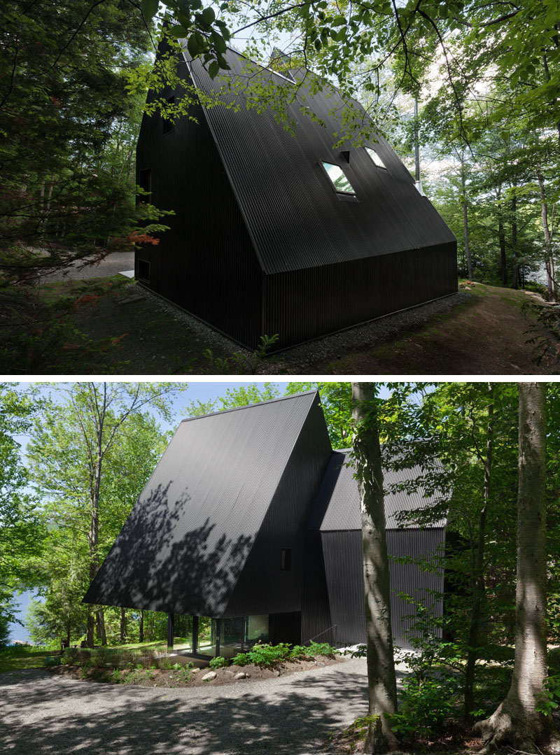 A modern forest cabin with a black exterior backyard