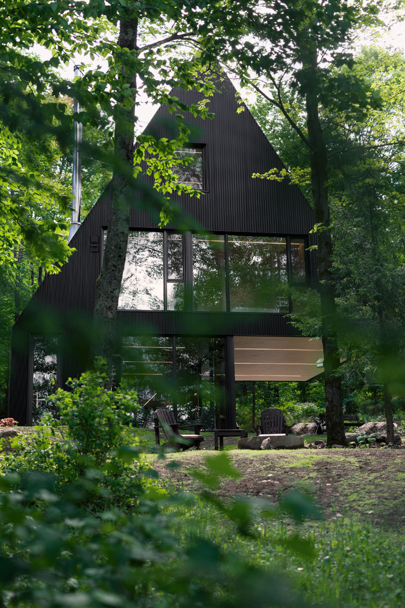 A modern forest cabin with a black exterior front view