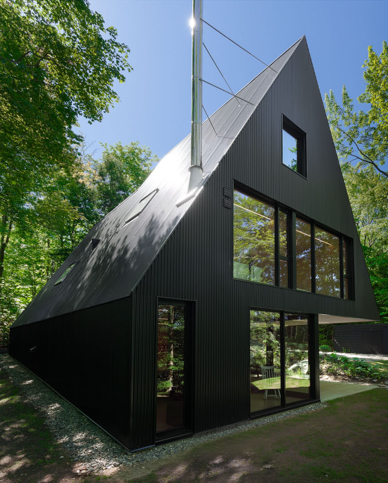 A modern forest cabin with a black exterior side view