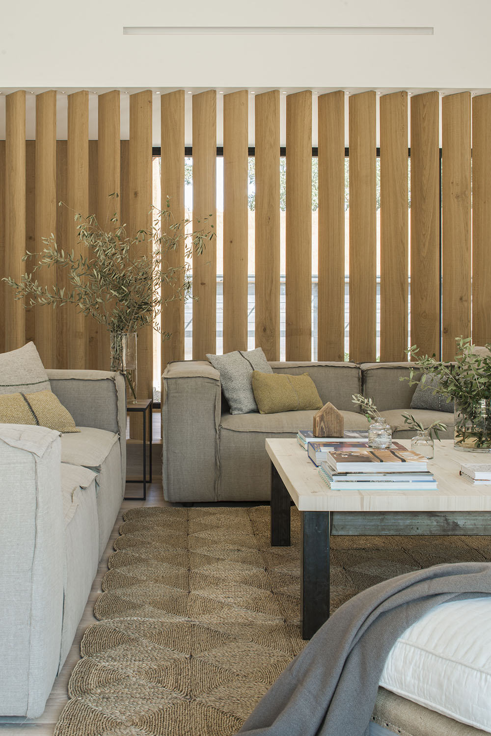 A slatted wall behind the sofa brings additional light into the space.