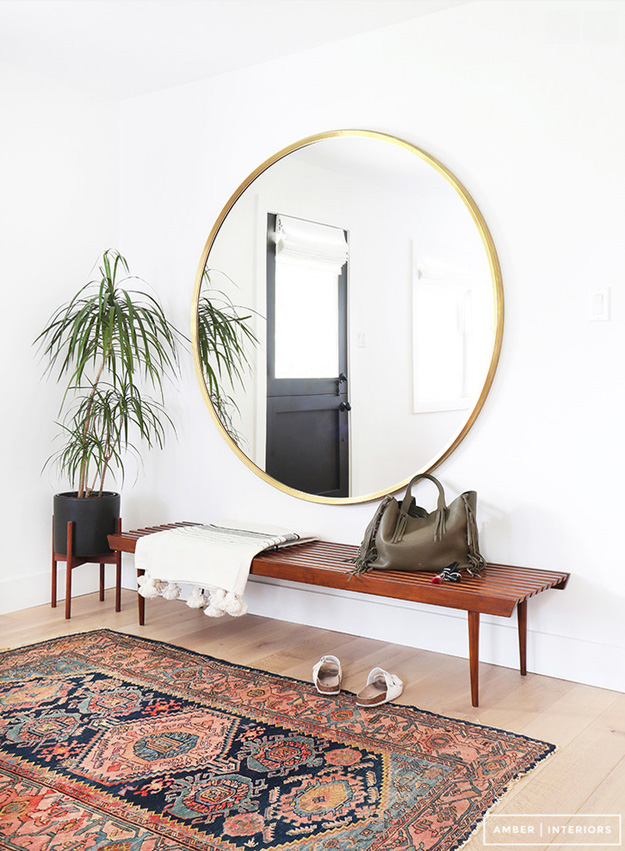 Amber Interior Foyer Design with Large round Mirror on the Wall and traditional Carpet