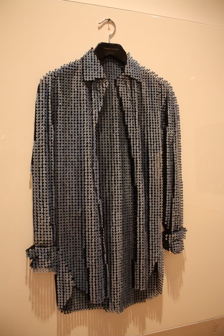 Myers' screw sculpture is also comprised of oil paint, a white automotive paint background, and a white metal frame.