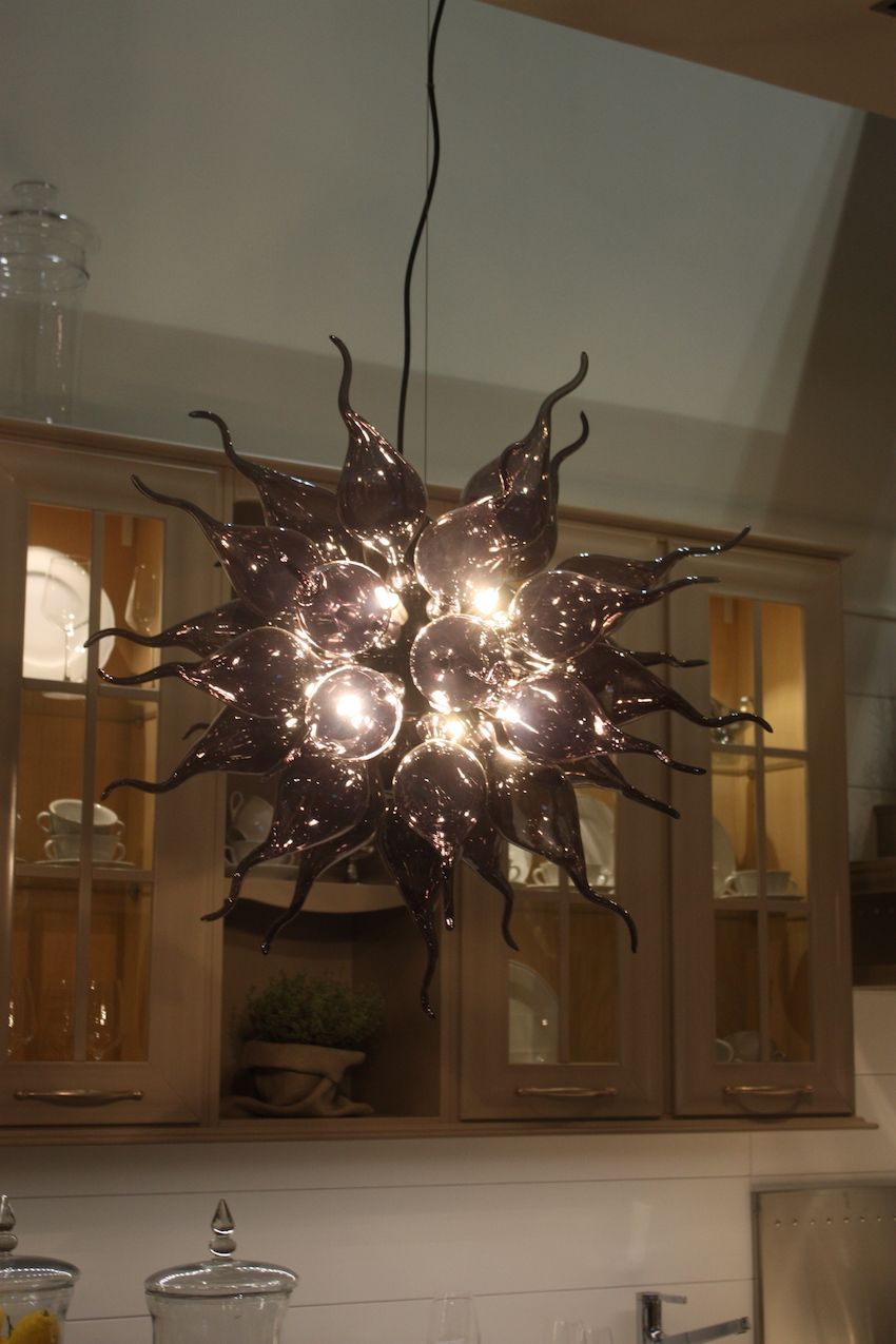 To make an artful statement, there's nothing like a blown glass light fixture. These types of fixtures will work anywhere in your home, even for kitchen lighting. Arcari used this dramatic chandelier for one of its kitchens.