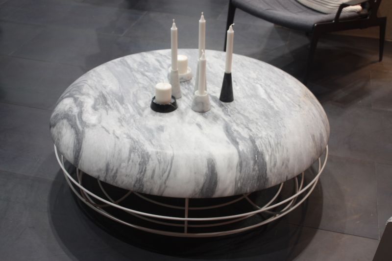 With the rounded shape of an ottoman, this marble topped coffee table by Atipico invites you to put your feet up as well. The rounded metal base adds to the impression that it's as much ottoman as table.