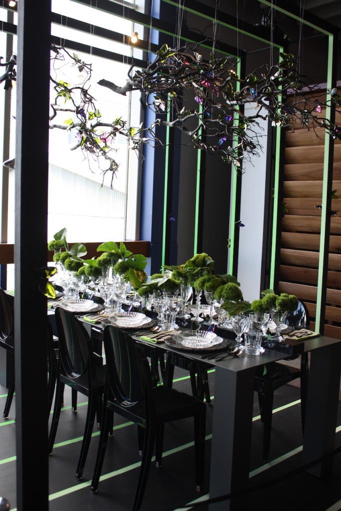 Baccarat crystal created this stunning dinner setting, with a mossy centerpiece running down the table and a chandelier of branches and multicolored lights.
