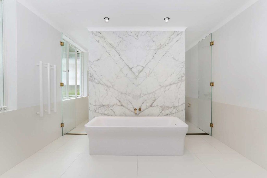 Bathroom with large marble wall and walk in shower