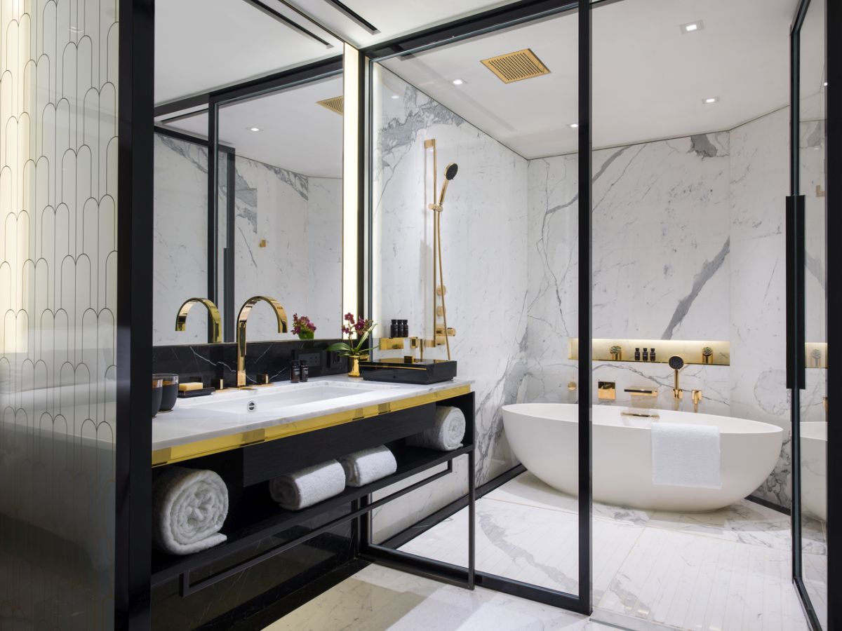 Bathroom with marble walls and gold fixtures