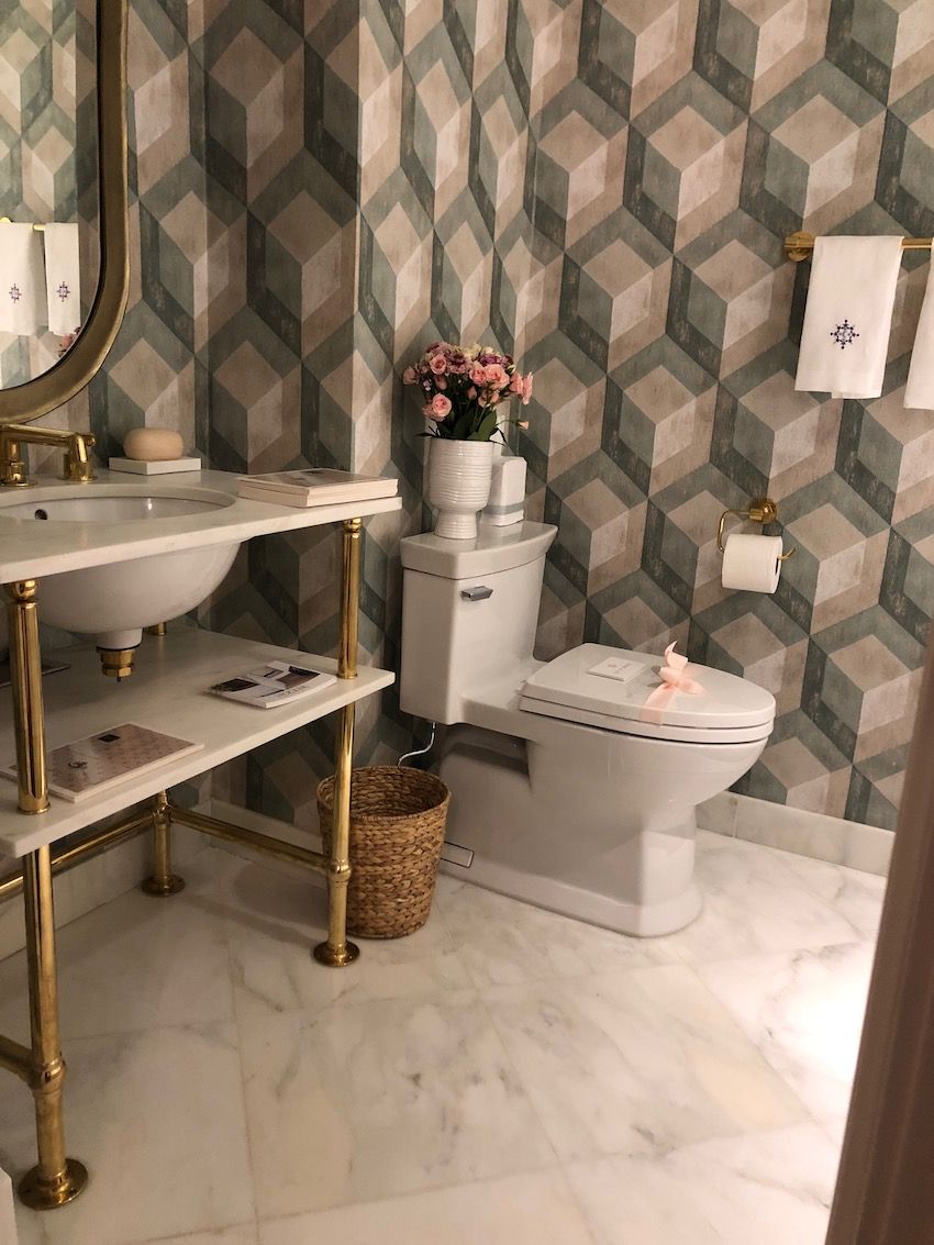 The accompanying bathroom takes the trellis design to a bold level in this modern geometric wallpaper.