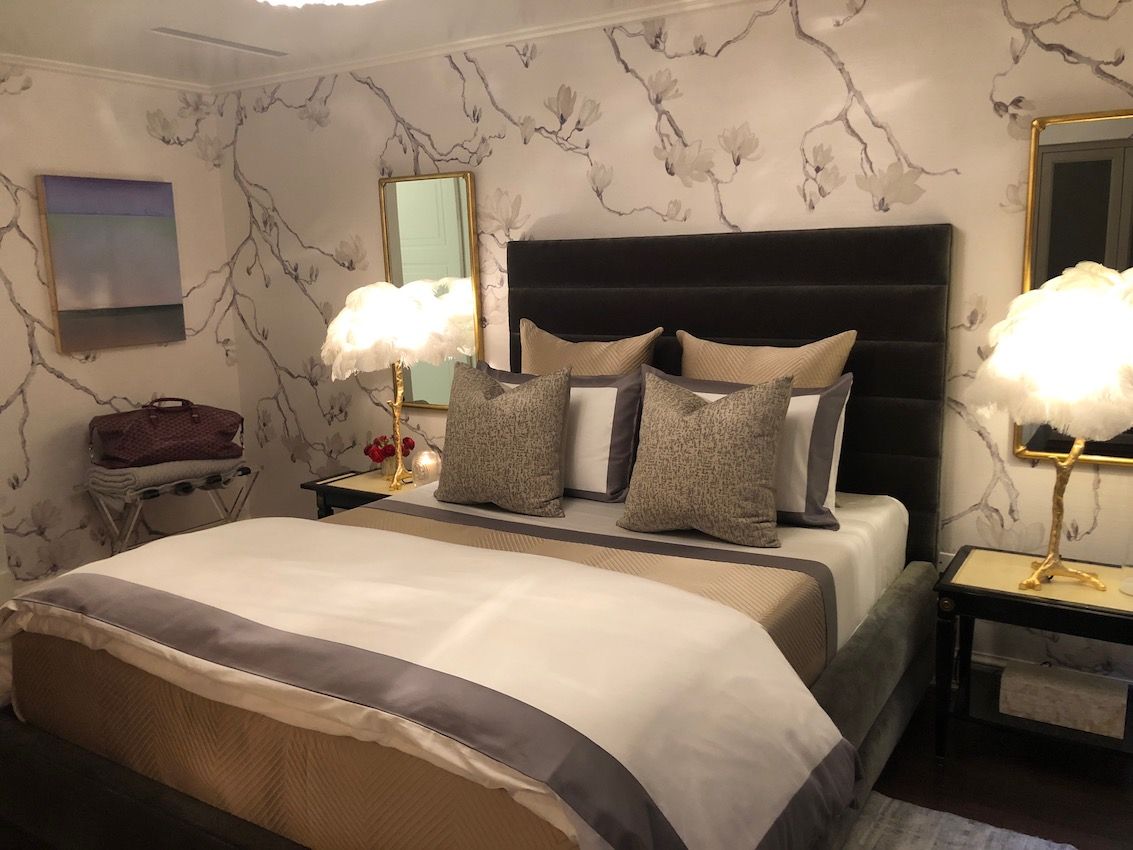 Feathery bedside lamps add a little something unexpected to the neutral space.
