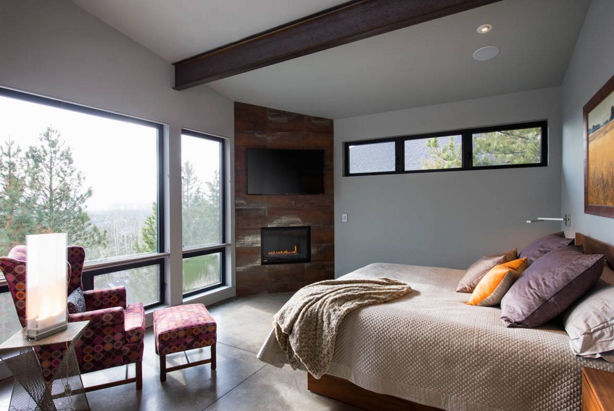 Bedroom with corner fireplace and reading chair