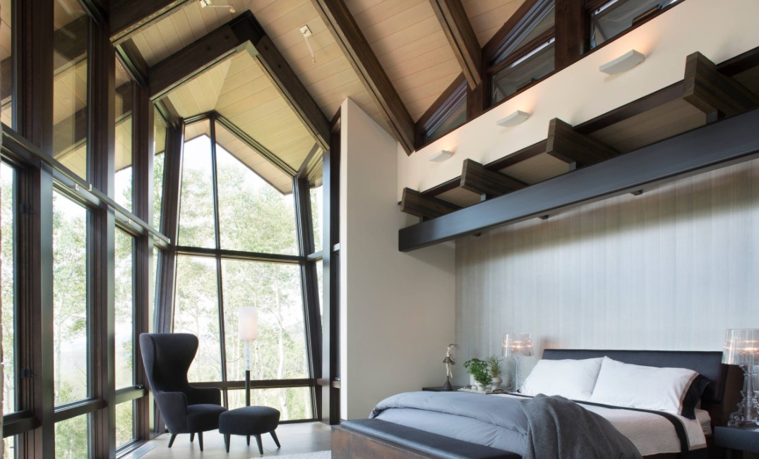 Bedroom with high ceiling and large wdnows